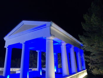 Low angle view of illuminated built structure against blue sky