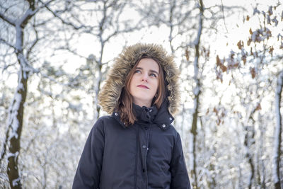 Girl standing in forest during winter