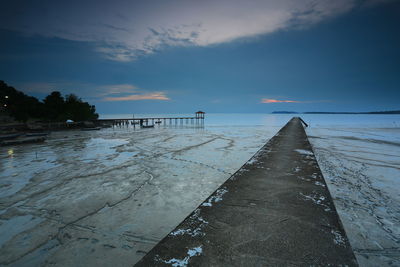 Pier over sea against sky during sunset