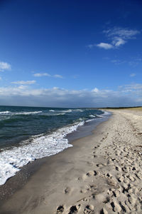 Scenic view of beach against blue sky