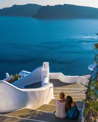 People in front of sea against mountains