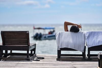 Woman lying on chair at beach
