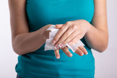 Close-up of woman holding hands over white background