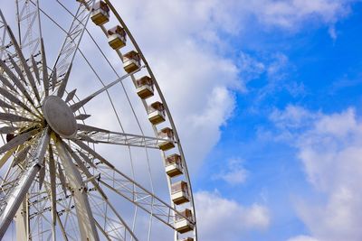 Low angle view of ferris wheel against blue sky