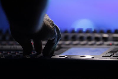 Cropped image of hand using sound mixer in nightclub