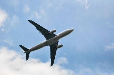 Low angle view of airplane flying against sky