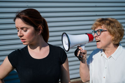 Portrait of woman standing against wall