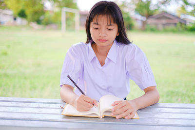 Young woman sitting on book