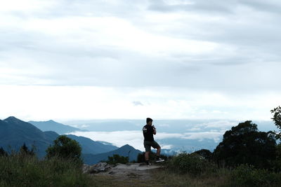 Man standing on mountain against sky