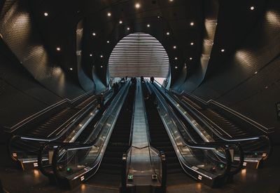 Low angle view of escalators in illuminated buildings