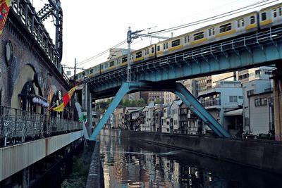 Bridge over river in city against clear sky