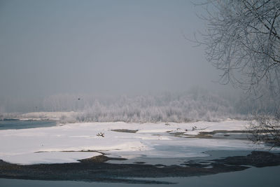 Scenic view of lake against clear sky during winter