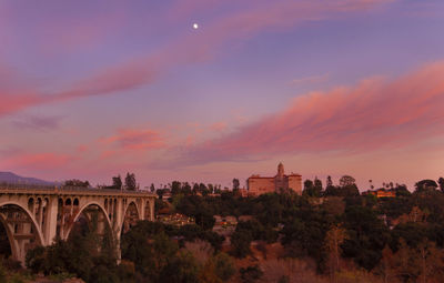 View of arch bridge and buildings against sky during sunset