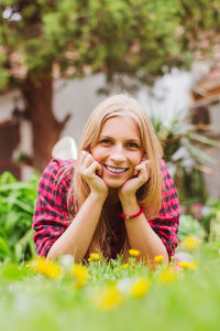 Portrait of smiling young woman lying on field