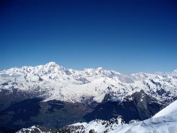 Scenic view of snowcapped mountains against clear blue sky