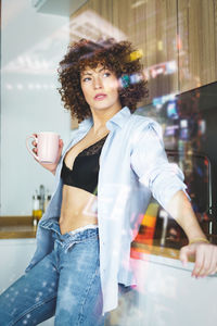 Portrait of young woman using mobile phone in cafe