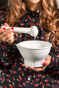 Midsection of woman holding mortar and pestle