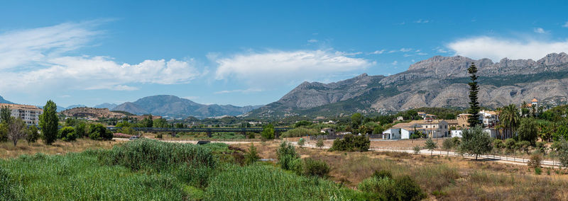 Scenic view of field by mountains against sky