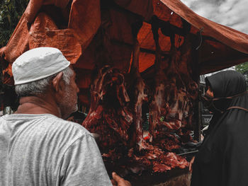 Rear view of man working on log