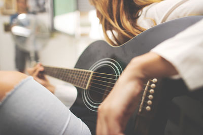 Midsection of man playing guitar