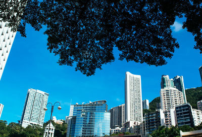 Low angle view of modern buildings against blue sky
