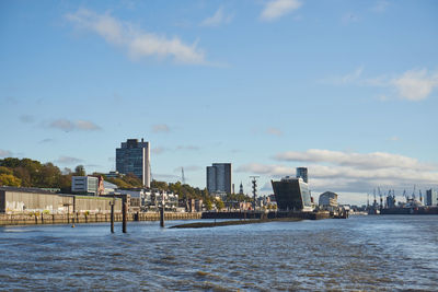 Sea by buildings against sky in city