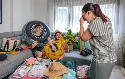 Side view of young woman sitting on sofa at home