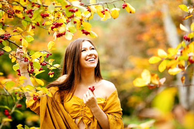 Portrait of smiling young woman against plants