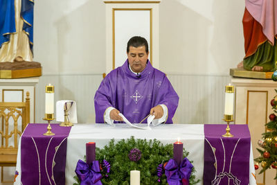 Priest reading paper in church during christmas