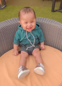 High angle portrait of cute baby girl sitting outdoors