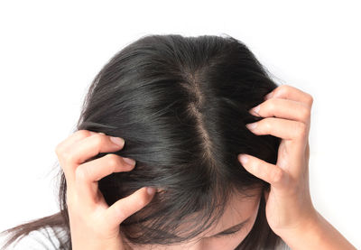 Close-up of woman with hand on white background