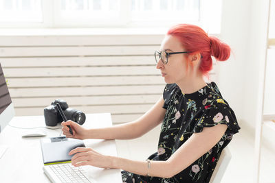 Side view of young woman using mobile phone