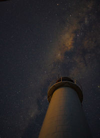 Low angle view of lighthouse against sky at night