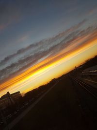 Panoramic view of road against dramatic sky during sunset