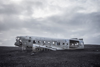 Abandoned airplane wreckage against sky