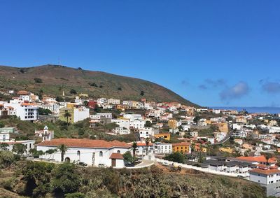 Buildings in town against clear blue sky