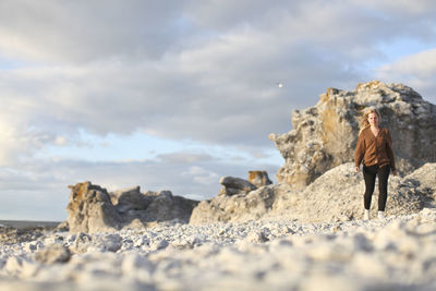 Woman walking through rocky landscape, faro, gotland, sweden