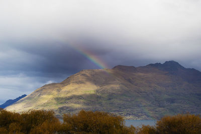 Rainbow over mountain against sky