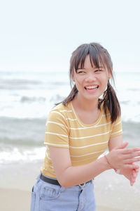 Happy woman standing at beach