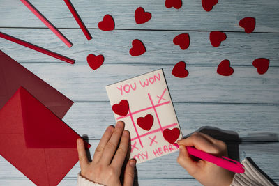 Cropped hands of woman writing on table