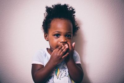 Portrait of cute girl against wall