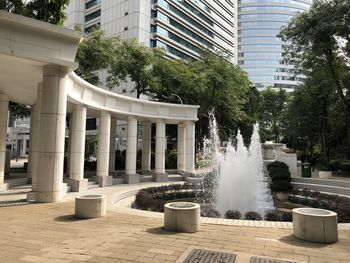 Fountain in city against buildings