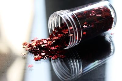 Close-up of red glittering stars on glass table