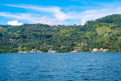 Scenic view of the lake against the mountain and the cloudy sky