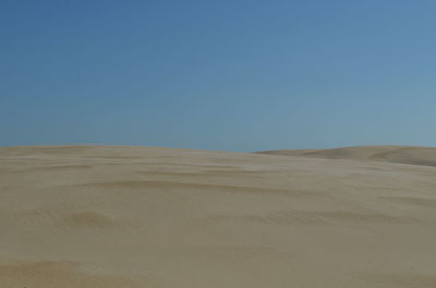 Scenic view of desert against clear blue sky