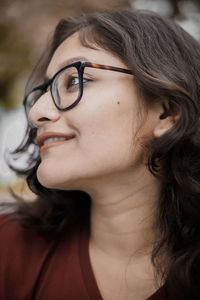 Close-up of young woman looking away sitting outdoors