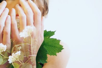 Close-up of woman hand by flowering plant