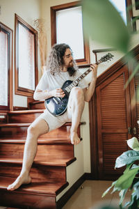 Man playing guitar at home