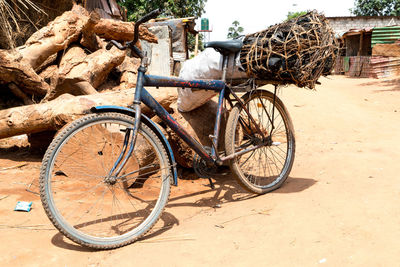 Bicycle parked on sand at beach during sunny day