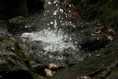 High angle view of water splashing on rock